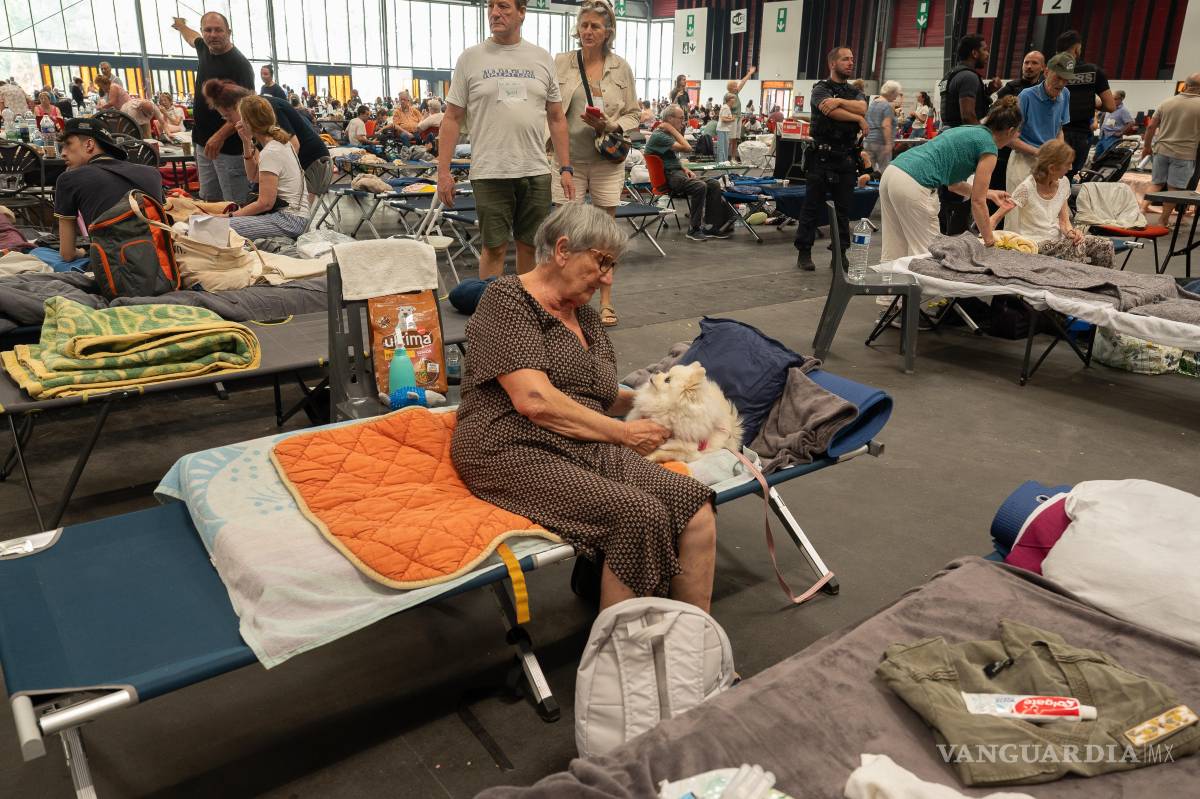 $!Una mujer acaricia a su perro en un refugio de emergencia instalado en el Centro de Exposiciones de Burdeos, Francia.