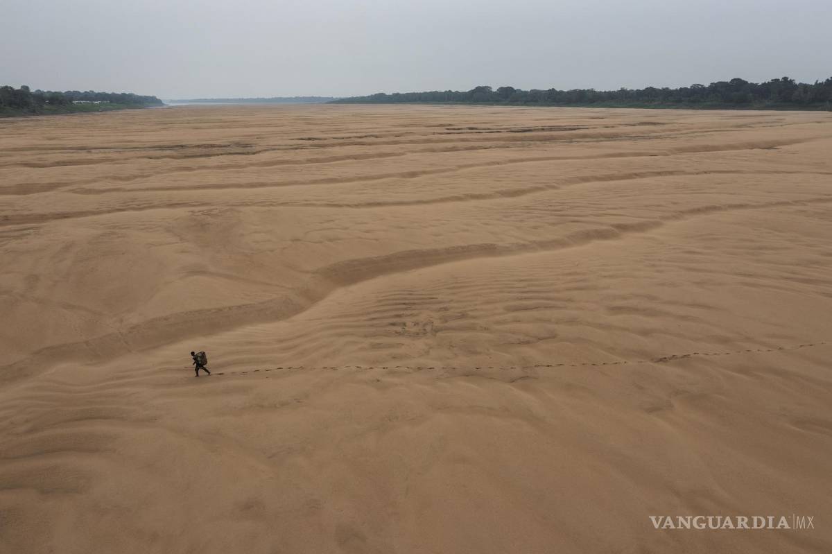 $!Imagen de Lalo de Almeida para Folha de Sao Paulo de un pescador caminando por el lecho seco de un brazo del río Amazonas en Brasil, 13 de octubre de 2023.