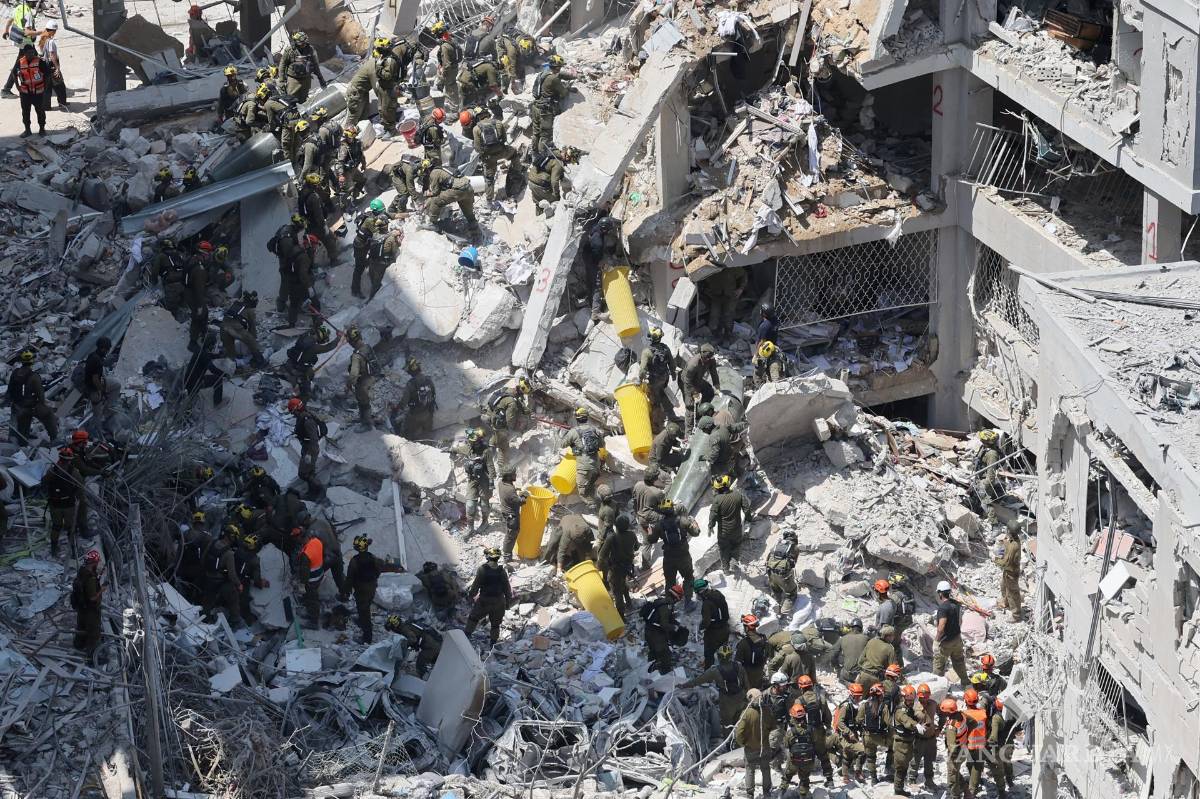 $!Miembros del Comando del Frente Interno de Israel buscan a personas desaparecidas bajo los escombros de un edificio residencial en Bat Yam.