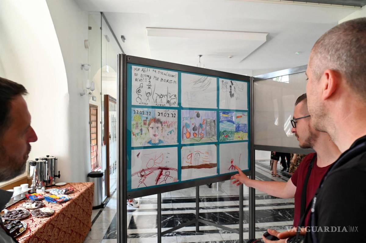 $!Personas miran los dibujos hechos por niños ucranianos en la exposición titulada ‘Guerra dibujada con un crayón’.