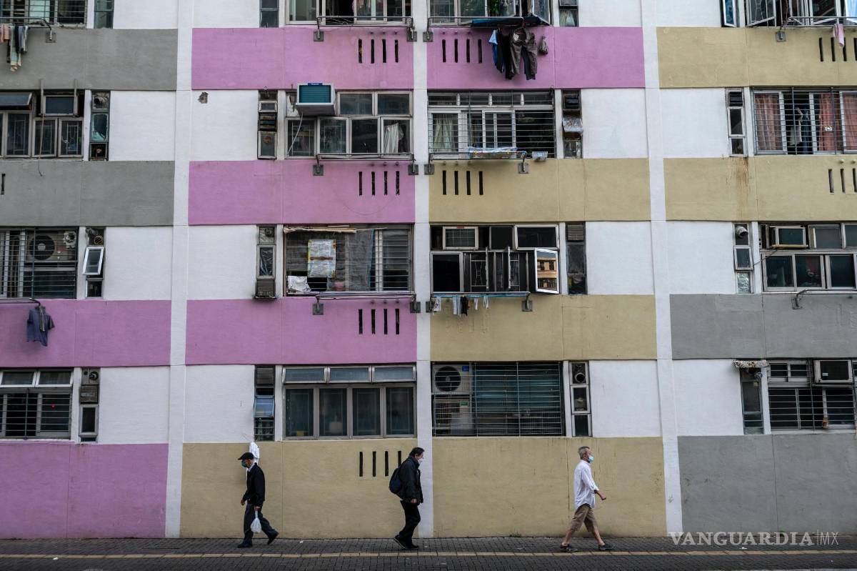 $!La gente pasa frente a edificios de viviendas públicas en Hong Kong.