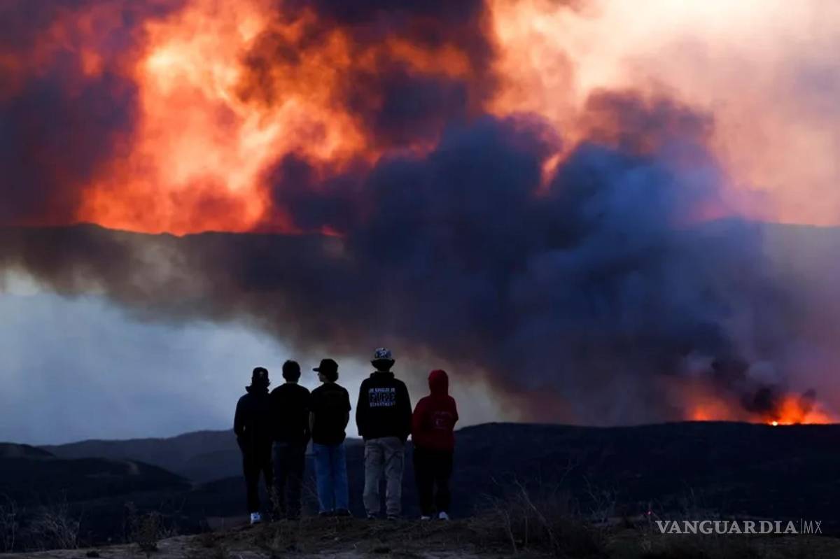 $!Un grupo de bomberos observa la evolución del incendio forestal de Hughes cerca de Santa Clarita, California.