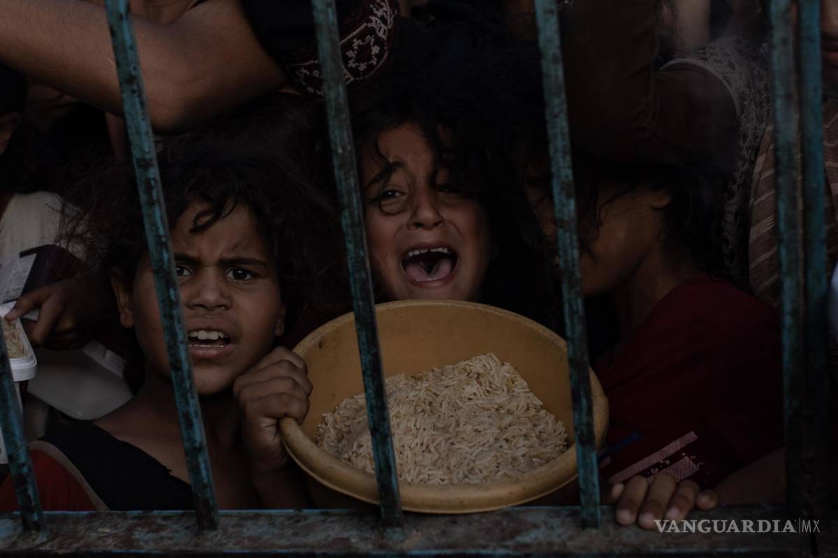 $!Niños en una reunión de palestinos desplazados para recoger alimentos donados por un grupo caritativo, en el campamento de Khan Yunis, en la Franja de Gaza.
