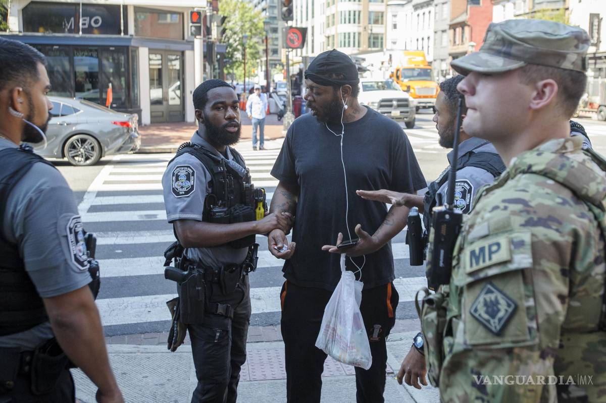 $!Miembros de la Guardia Nacional a un Policía de Tránsito Metropolitano habla con un hombre después de bajarlo de un autobús del Metro en Washington.