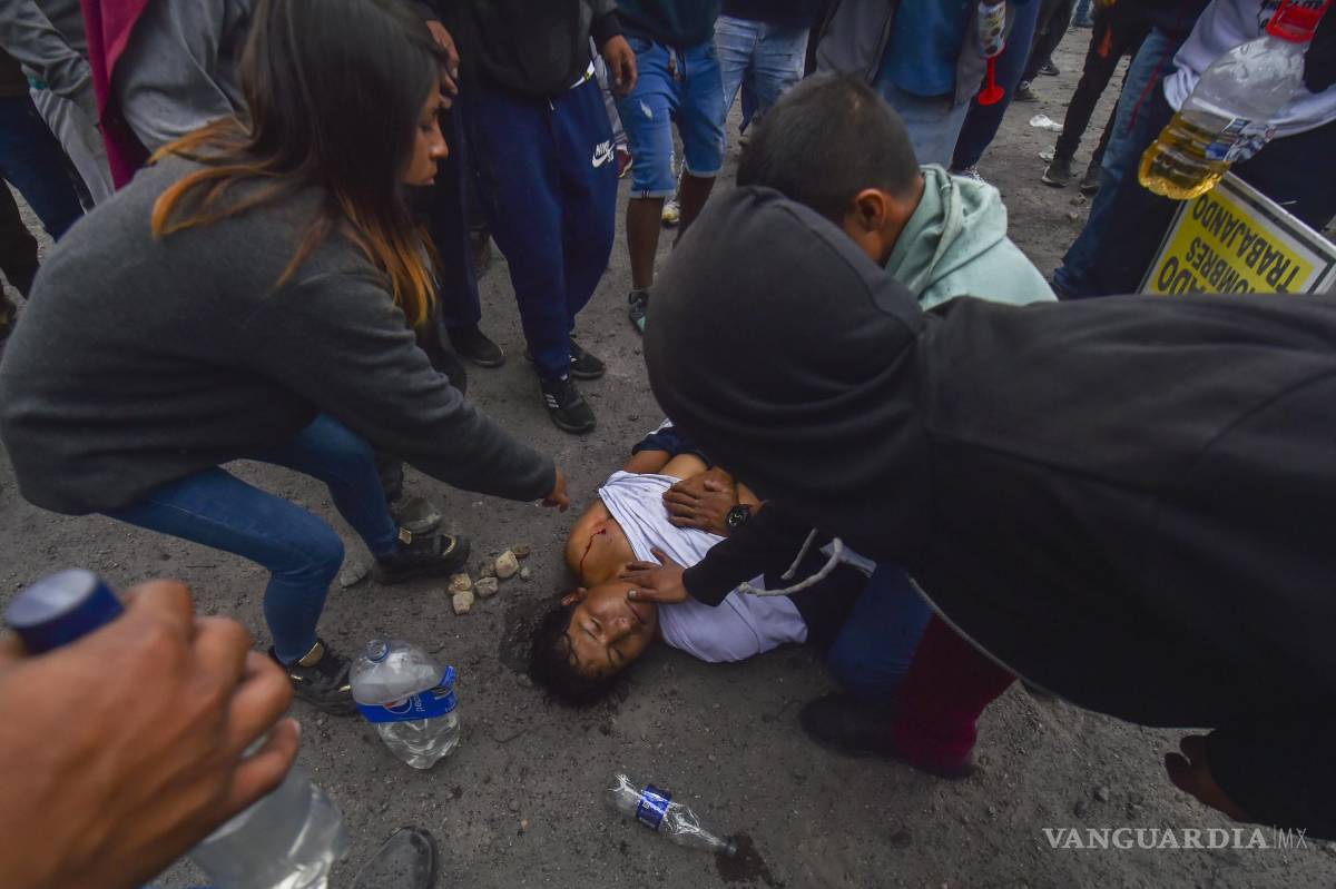 $!Personas ayudan a un hombre herido en las protestas contra el gobierno en Arequipa, Perú.