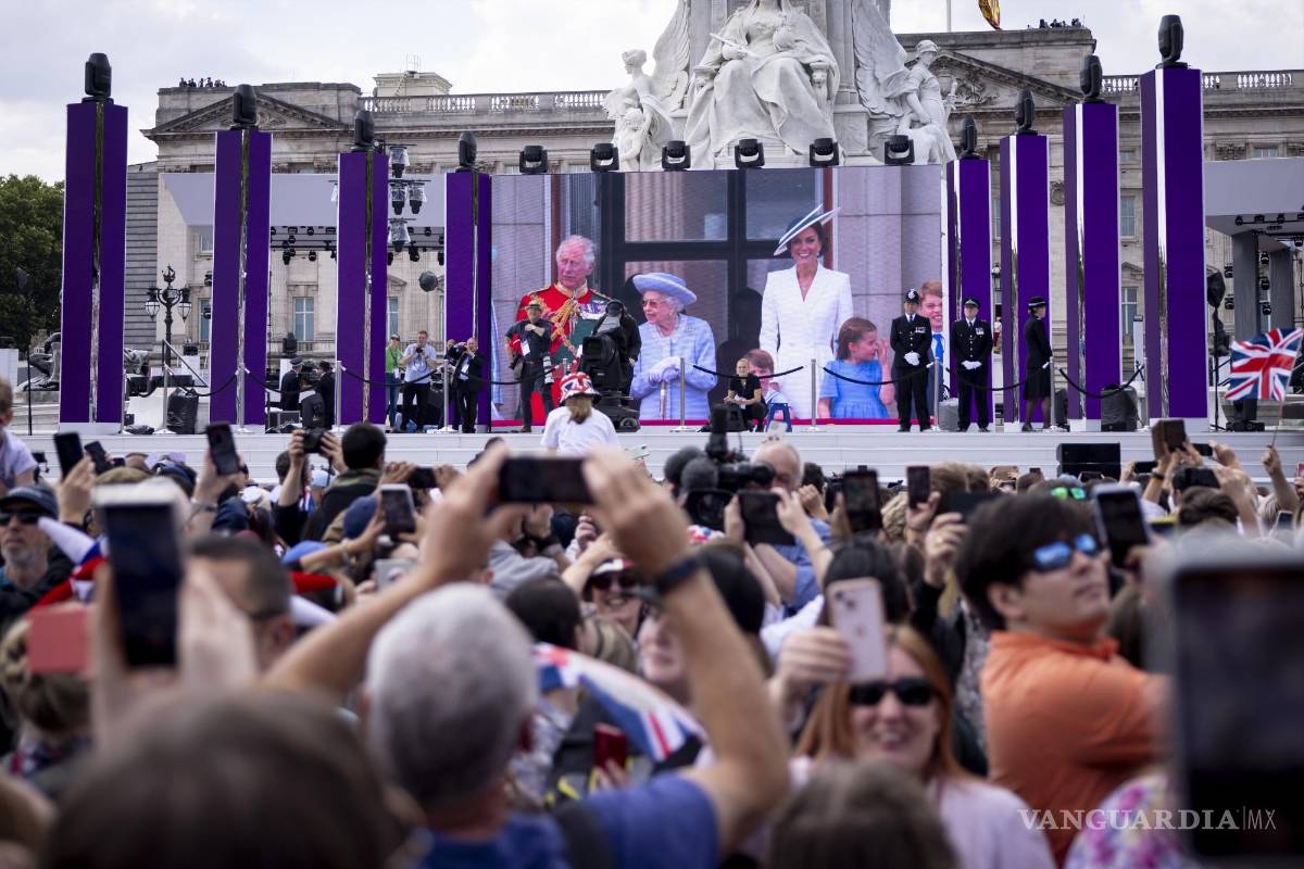$!Gente en un centro comercial viendo a Su Majestad, la Reina y miembros de la familia real en el balcón del Palacio de Buckingham.