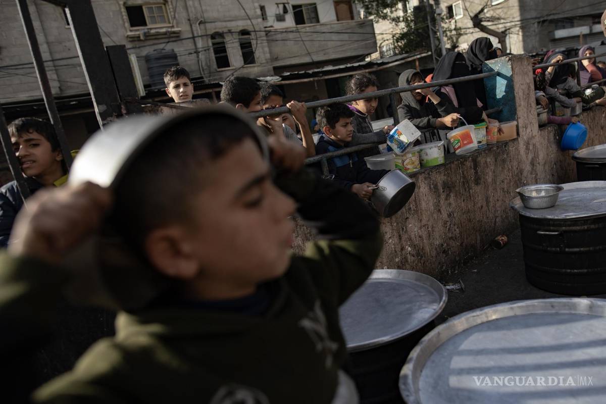 $!Palestinos desplazados se reúnen para recoger alimentos donados por un grupo benéfico antes del desayuno, el cuarto día del mes sagrado del Ramadán en Rafah.