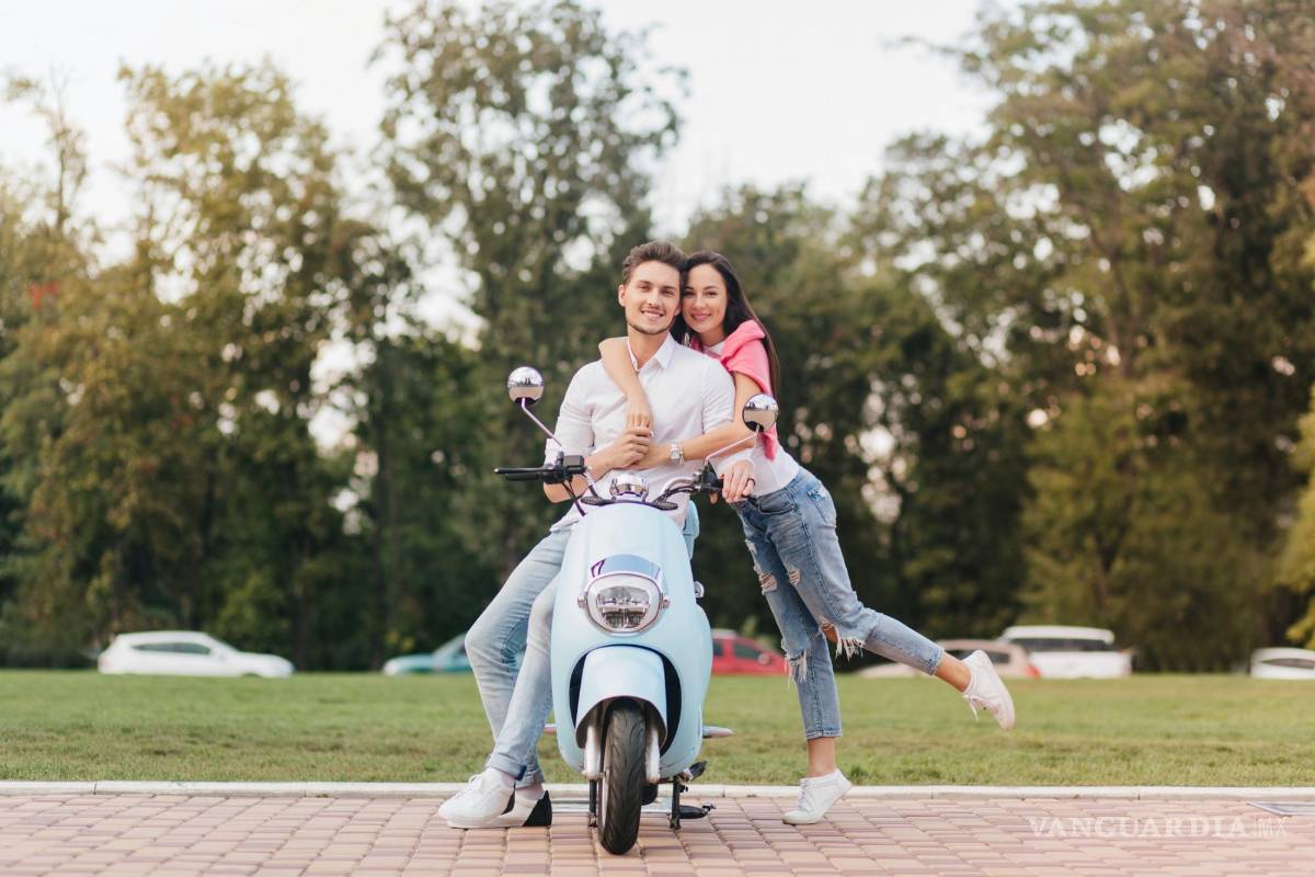 $!Una pareja de adolescentes junto a su vehículo de dos ruedas.