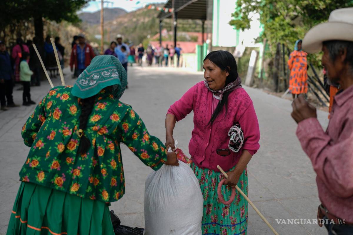 $!Una mujer rarámuri, a la izquierda, que representa al equipo en la competencia de carreras de Arihueta, recoge sus ganancias del representante del equipo contrario.