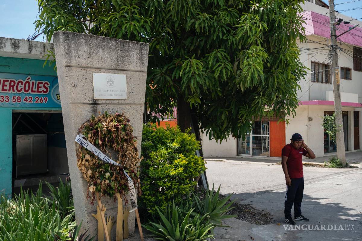 $!Ulises Martínez, ex alumno de la escuela Normal Rural Raúl Isidro Burgos, junto a un monumento en honor de los estudiantes asesinados hace 10 años.