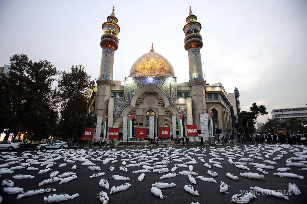 $!Cadáveres simulados en homenaje a los niños que murieron en la guerra de Israel en solidaridad con el pueblo palestino, en la Plaza Palestina, en Teherán, Irán.