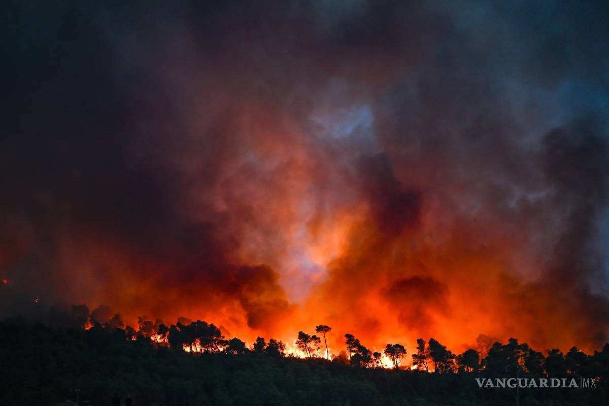 $!Las llamas envuelven una zona boscosa durante un incendio forestal en Saint-Laurent-de-la-Cabrerisse, departamento de Aude, Francia.