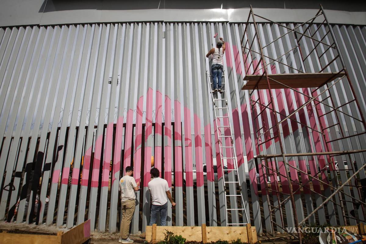 $!Artistas pintan con colores el nuevo muro instalado en la frontera con Estados Unidos para protestar por la renovación de la pared y por la crisis migratoria que se vive en la zona este sábado, en Tijuana.