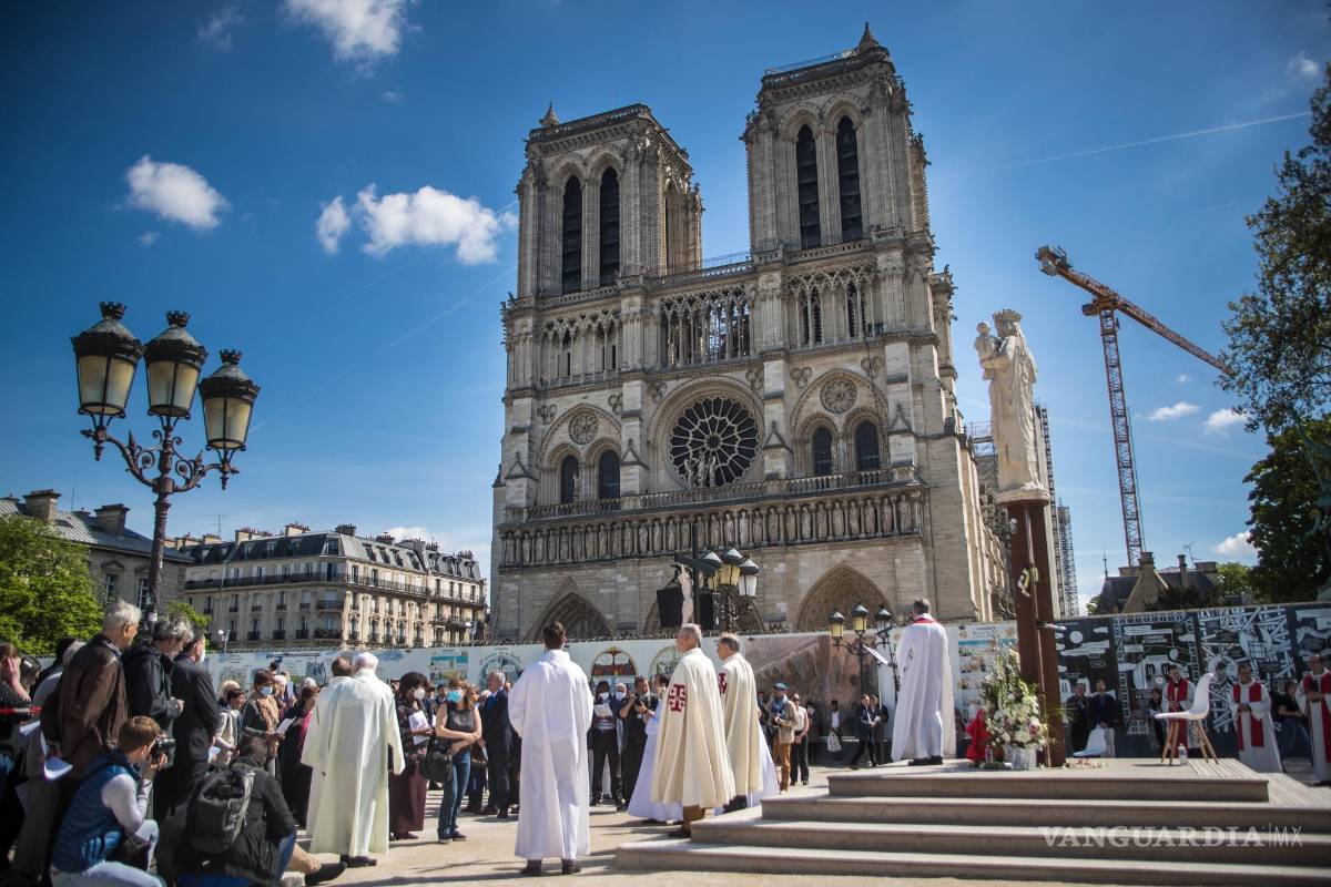 $!Fieles y sacerdotes participan en una procesión el Viernes Santo frente a la Catedral de Notre-Dame como parte de las celebraciones del Viernes Santo en París, Francia.