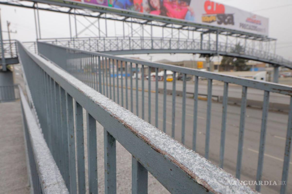 $!La caída de aguanieve complica sujetarse del barandal.