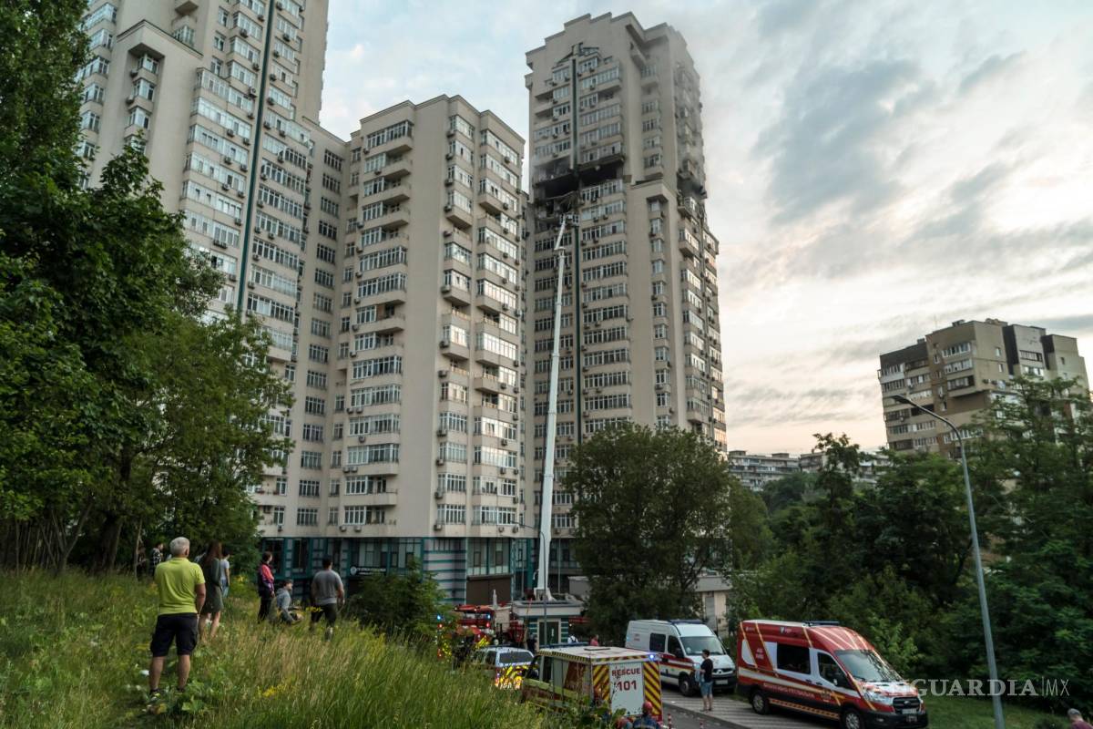 $!Los residentes y los servicios de emergencia se reunieron frente a un edificio residencial de gran altura que fue alcanzado por un misil en Kiev, Ucrania.