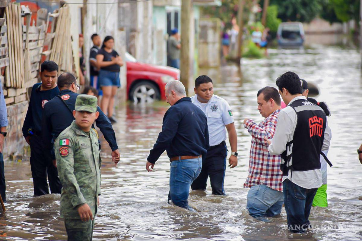 $!El alcalde de Torreón, Román Alberto Cepeda González, camina las calles de la colonia Santiago Ramírez, la más afectada por las inundaciones pluviales.