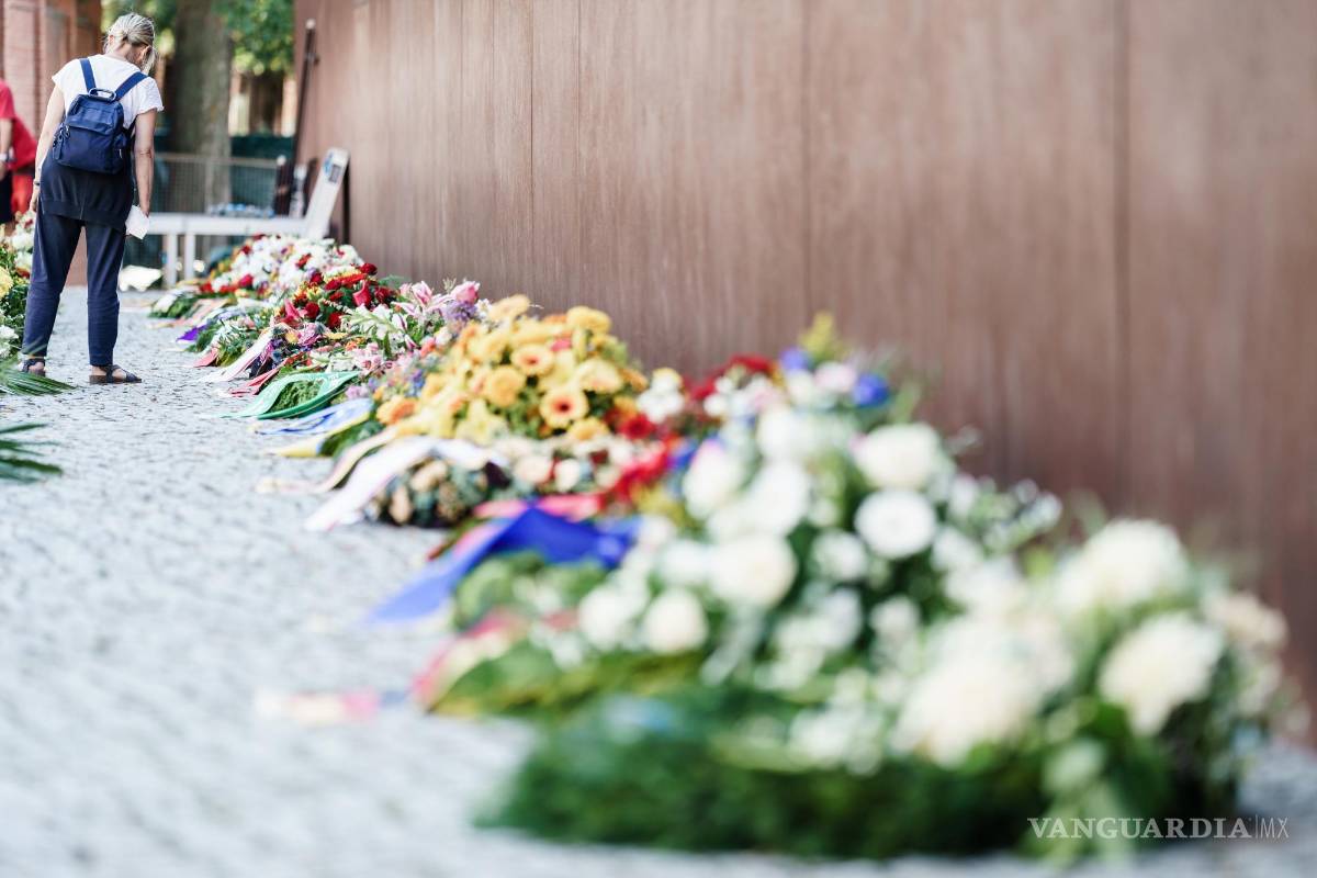 $!Una mujer mira coronas de flores después de la ceremonia de conmemoración del 60 aniversario de la construcción del Muro de Berlín en el Monumento al Muro de Berlín en Berlín, Alemania. EFE/EPA/Clemens Bilan