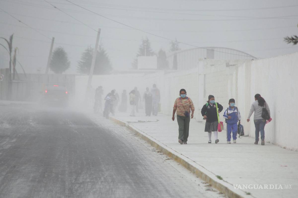 $!18/04/2016. Pobladores caminan sobre las calles cubiertas de ceniza de San Andrés Cholla, México, después de que el volcán Popocatépetl hiciera erupción.