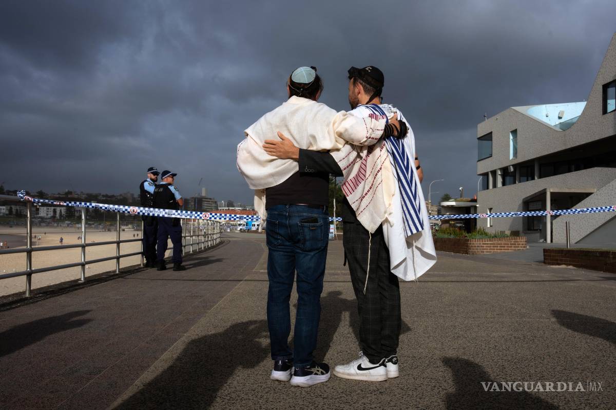 $!Dos hombres judíos se abrazan tras la oración matutina en el lugar del mortal tiroteo en Bondi Beach, Sídney, Australia.