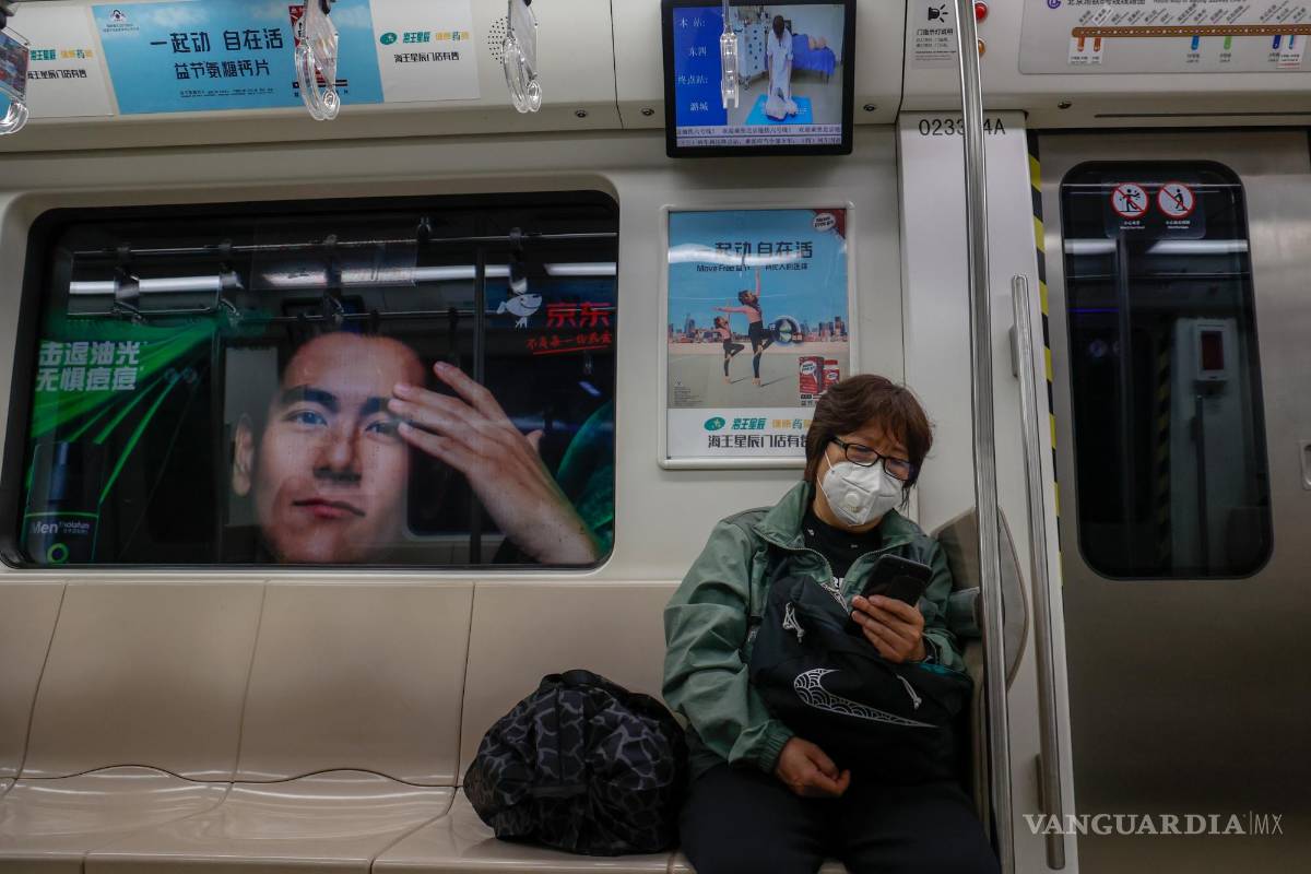 $!Una mujer usa su teléfono móvil dentro de un tren en Beijing, China.