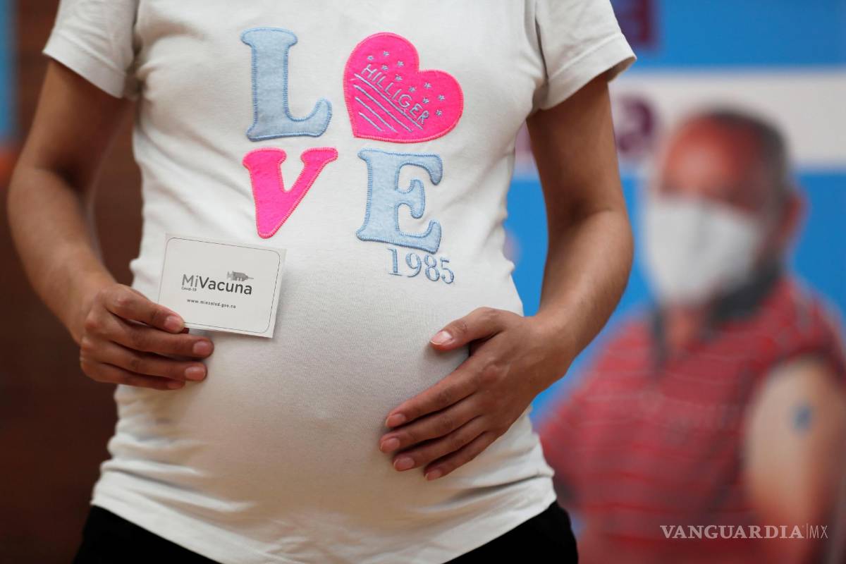 $!Una mujer embarazada muestra su carnet de vacunación luego de recibir la vacuna de Pfizer contra la covid-19 autorizada para madres gestantes, hoy, en el coliseo Cayetano Cañizares en Bogotá (Colombia).