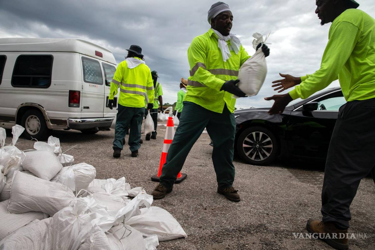 $!Trabajadores y voluntarios de la ciudad de St Petersburg en Florida entregan sacos de arena a los residentes mientras la ciudad se prepara para el huracán Ian.