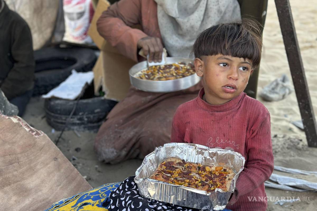 $!Un niño come un plato del Iftar, que marca la ruptura del ayuno en ramadán en Rafah, Gaza.