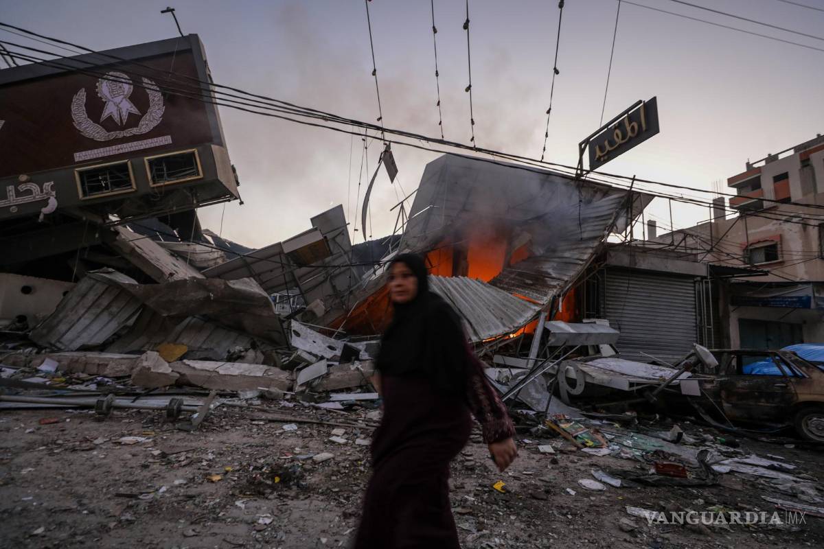 $!Una mujer palestina camina junto a una panadería destruida en el campo de refugiados de Al Nusairat, en el centro de la Franja de Gaza.