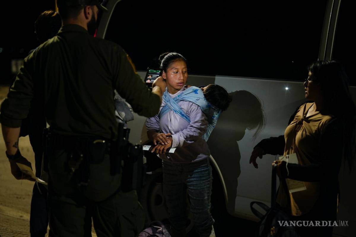 $!Una mujer de Ecuador responde las preguntas de un agente de la Patrulla Fronteriza mientras espera para solicitar asilo después de cruzar la frontera.