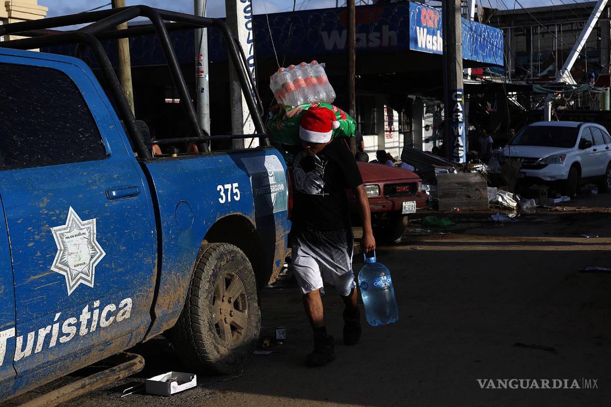 $!Fotografía que muestra a una persona mientras con objetos saqueados una tienda de autoservicio por el paso del huracán Otis en Acapulco, en Guerrero (México).