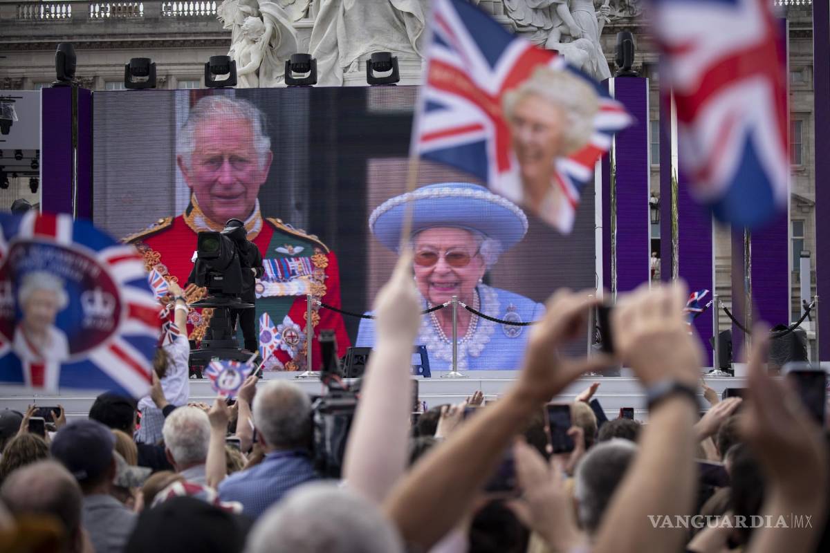 $!Personas en un centro comercial observa a Su Majestad, la Reina y el Príncipe de Gales en el balcón del Palacio de Buckingham en una pantalla gigante.
