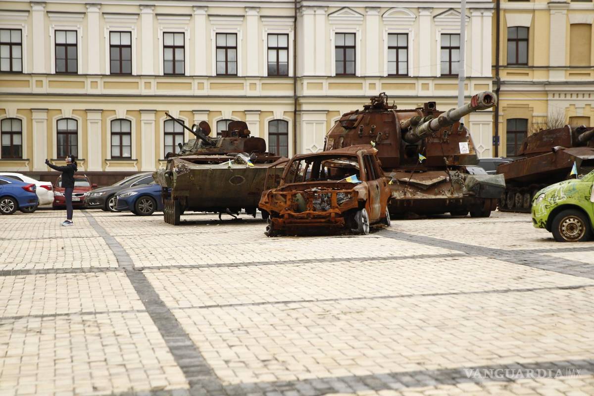 $!Una mujer se hace un selfi frente a los vehículos militares rusos calcinados expuestos ante la Catedral de San Miguel de las Cúpulas Doradas en Kiev.
