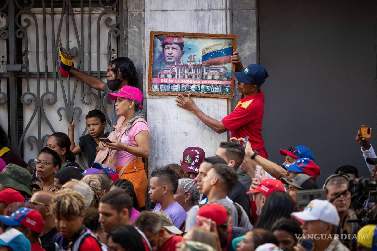 $!Un hombre sostiene un cuadro con la imagen del expresidente fallecido Hugo Chávez en Caracas, Venezuela.