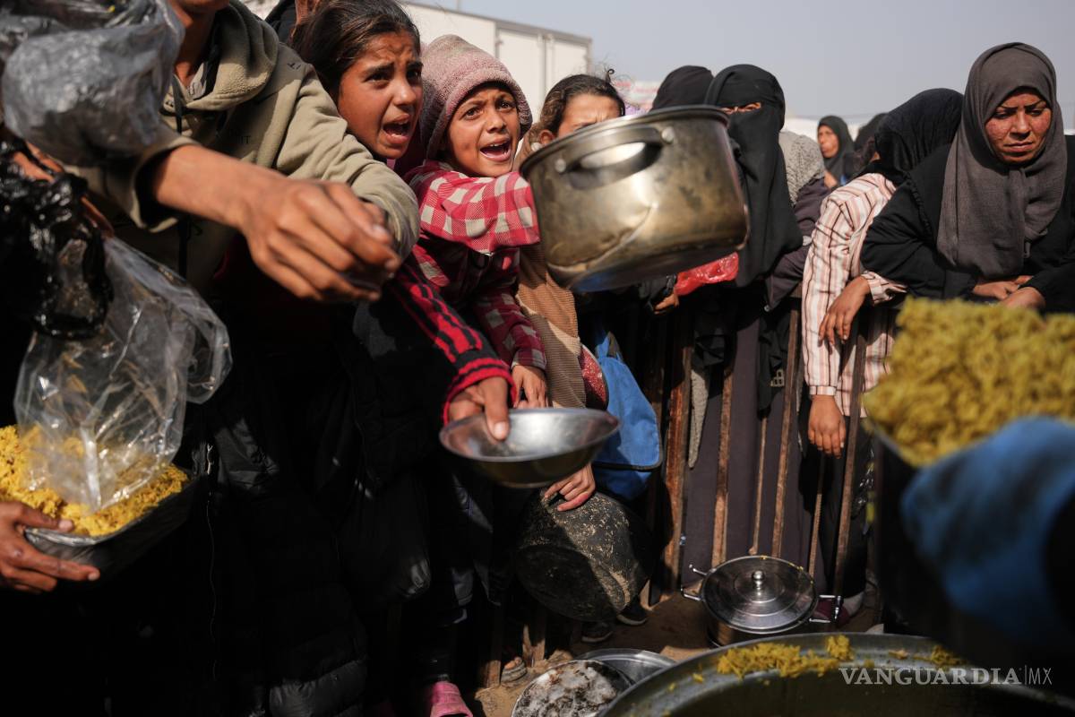 $!Palestinos esperan recibir alimentos donados en un centro de distribución en Khan Younis, al sur de la Franja de Gaza, el viernes 23 de enero de 2026.