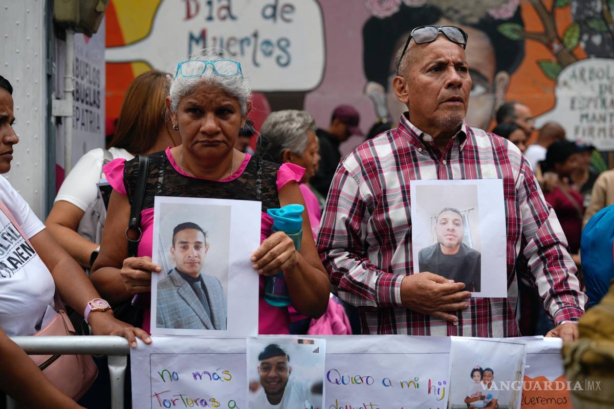 $!Personas con fotografías de parientes migrantes, de los que dicen fueron detenidos en EU y aguardan a ser deportados, protestan en Caracas.