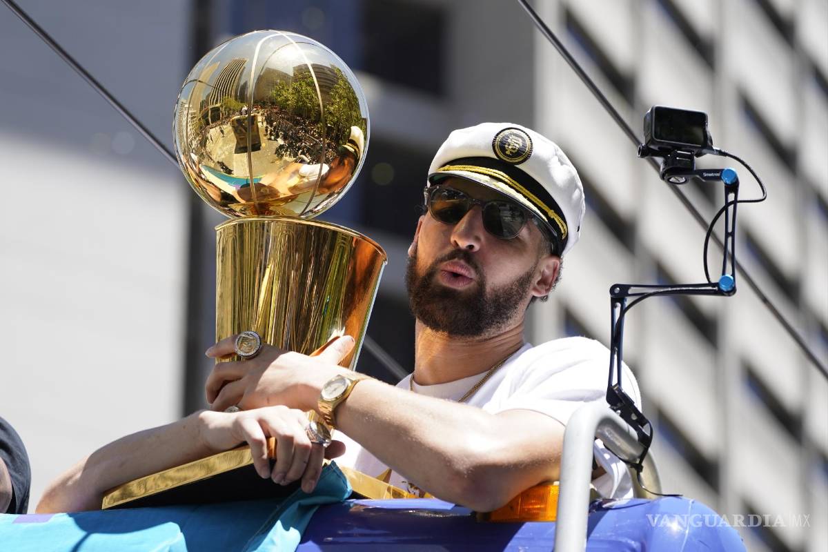 $!Klay Thompson porta una gorra de capitán y sostiene el trofeo de campeones de la NBA, durante el recorrido del desfile de celebración del título de la NBA de los Warriors de Golden State, el lunes 20 de junio de 2022, en San Francisco. (AP Foto/Eric Risberg)