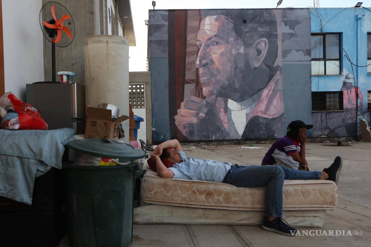 $!Un hombre duerme al aire libre, a la intemperie, bajo un mural del difunto presidente venezolano Hugo Chávez, en Catia La Mar, Venezuela.