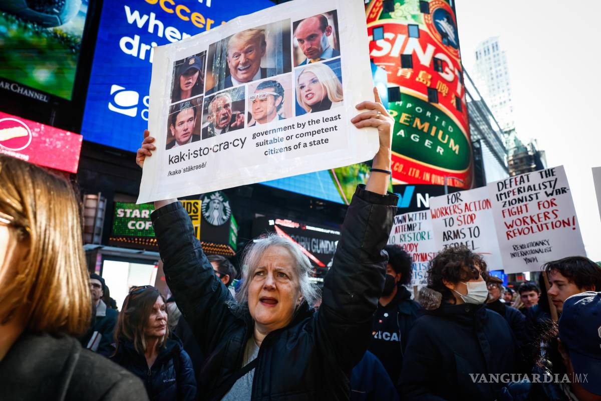 $!Una mujer con una pancarta con imágenes de Donald Trump y miembros de su gabinete durante una protesta contra los ataques de EU contra Irán, en Nueva York.