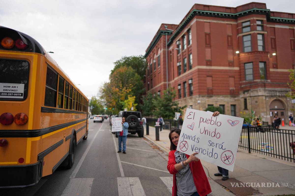 $!La maestra de primer grado, María Heavener, con un cartel que dice en español: “El pueblo, unido, jamás será vencido”, en el barrio de Logan Square de Chicago.
