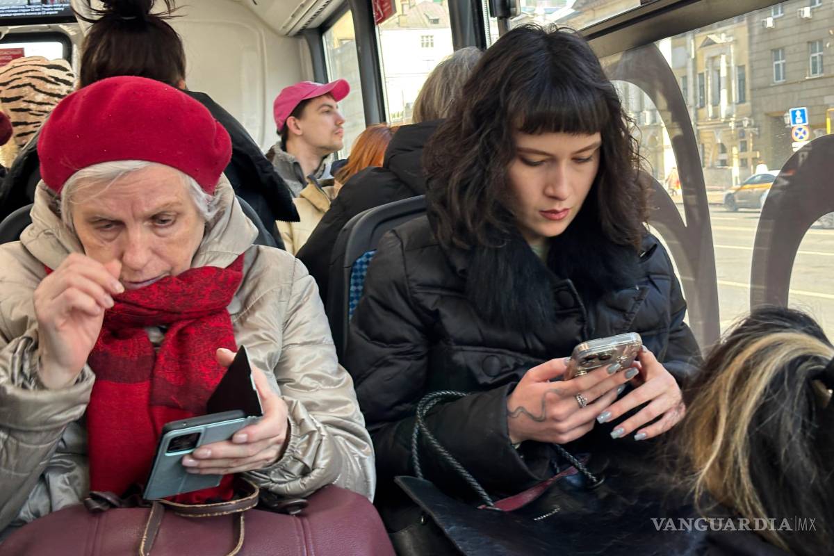 $!Dos mujeres consultan sus celulares durante un viaje en bus en Moscú.