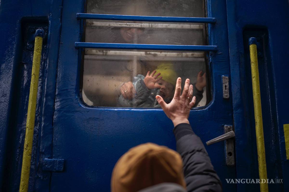 $!Stanislav se despide de su hijo de dos años David y de su esposa Anna luego de que embarcasen en un tren que los llevaría a Leópolis, en la estación de Kiev, Ucrania.