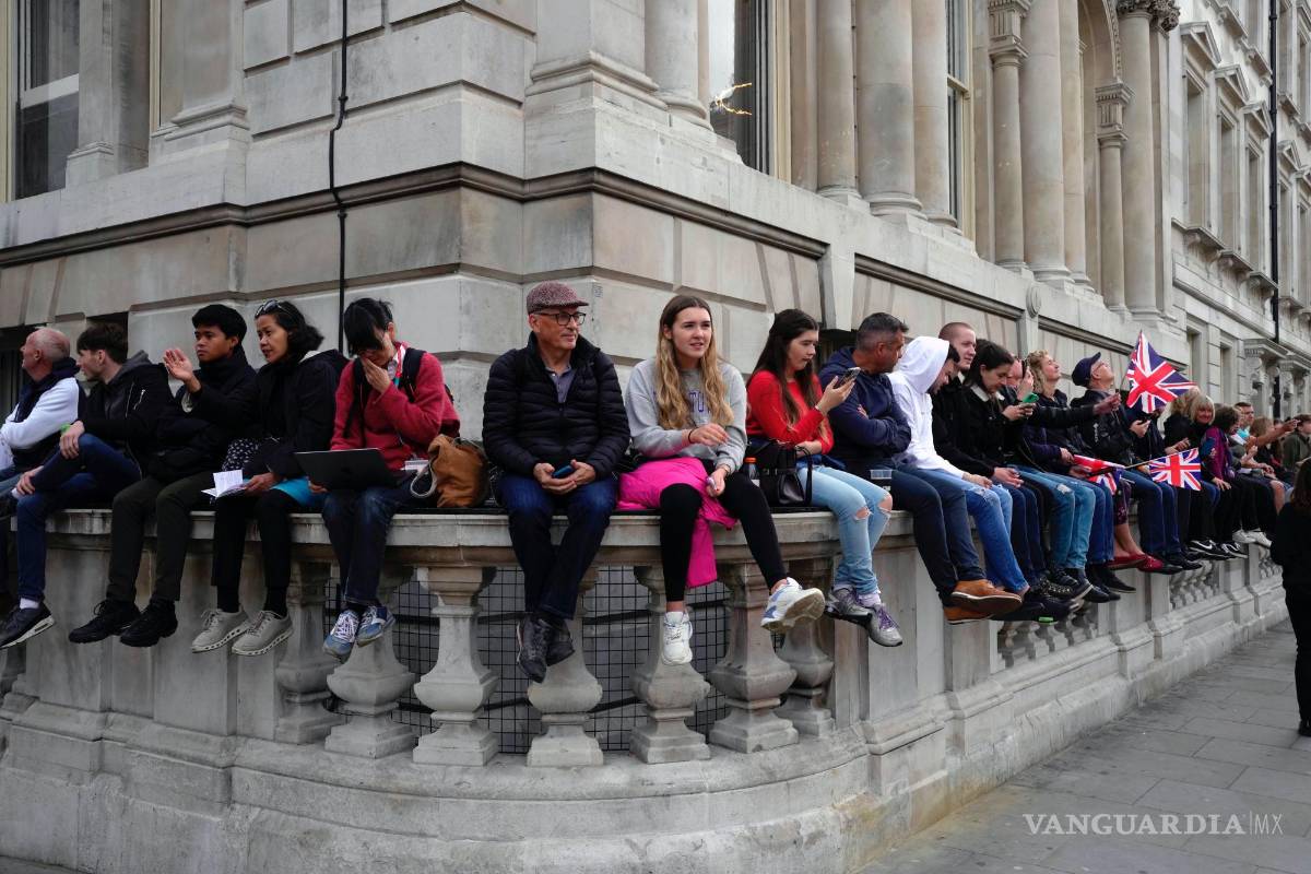 $!La gente se reúne para la procesión del ataúd de la reina Isabel II desde el Palacio de Buckingham hasta el Westminster Hall, en Londres.