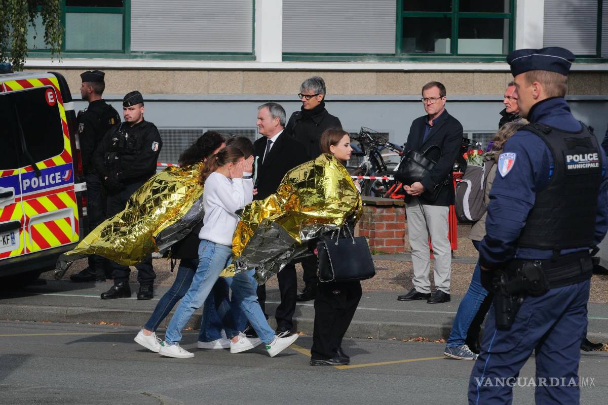 $!Policías escoltan a niños ante la escuela Gambetta durante una amenaza de bomba el lunes 16 de octubre de 2023 en Arras, en el norte de Francia.