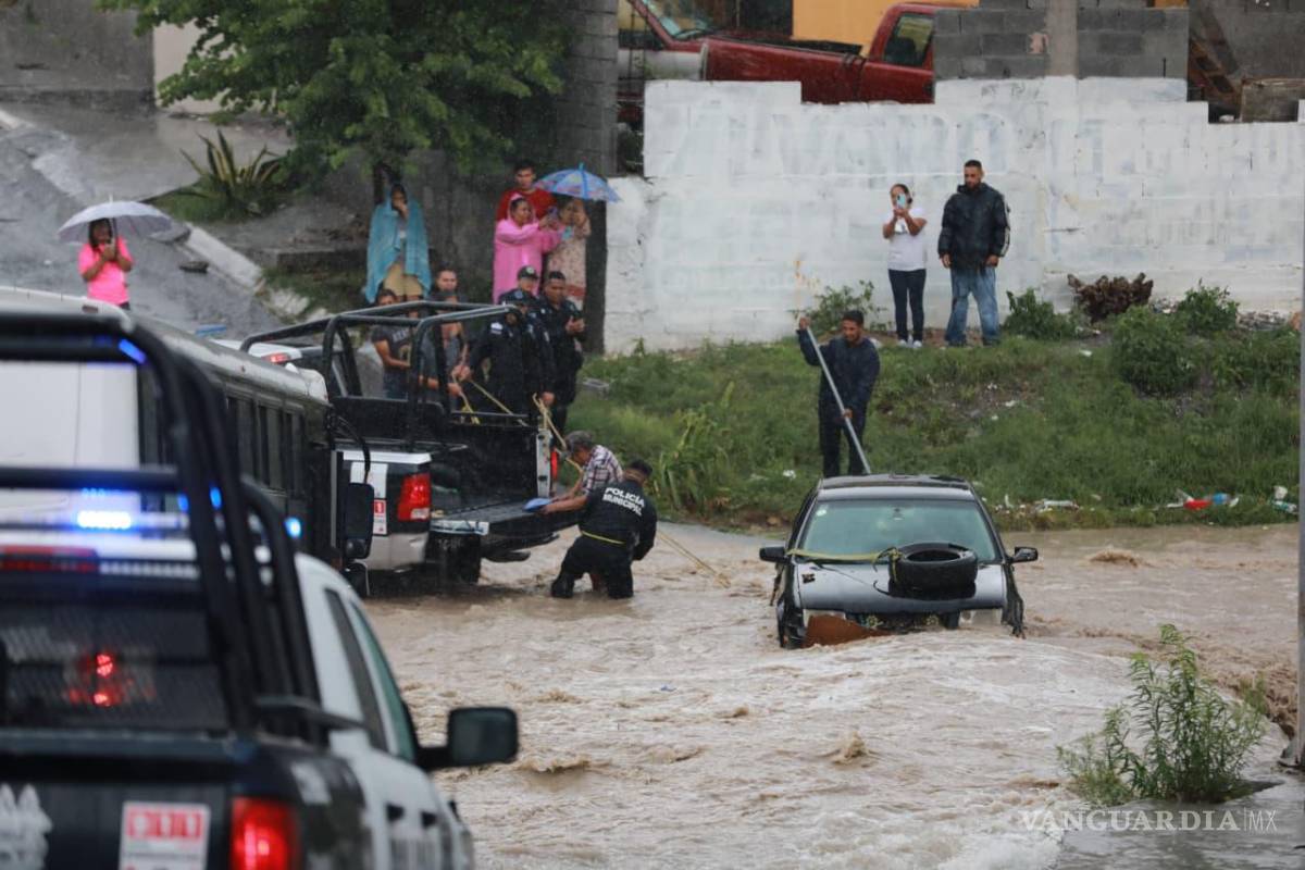 $!Elementos de la Policía Municipal rescataron a un automovilista que quedó atrapado por la corriente de agua en la colonia Australia.