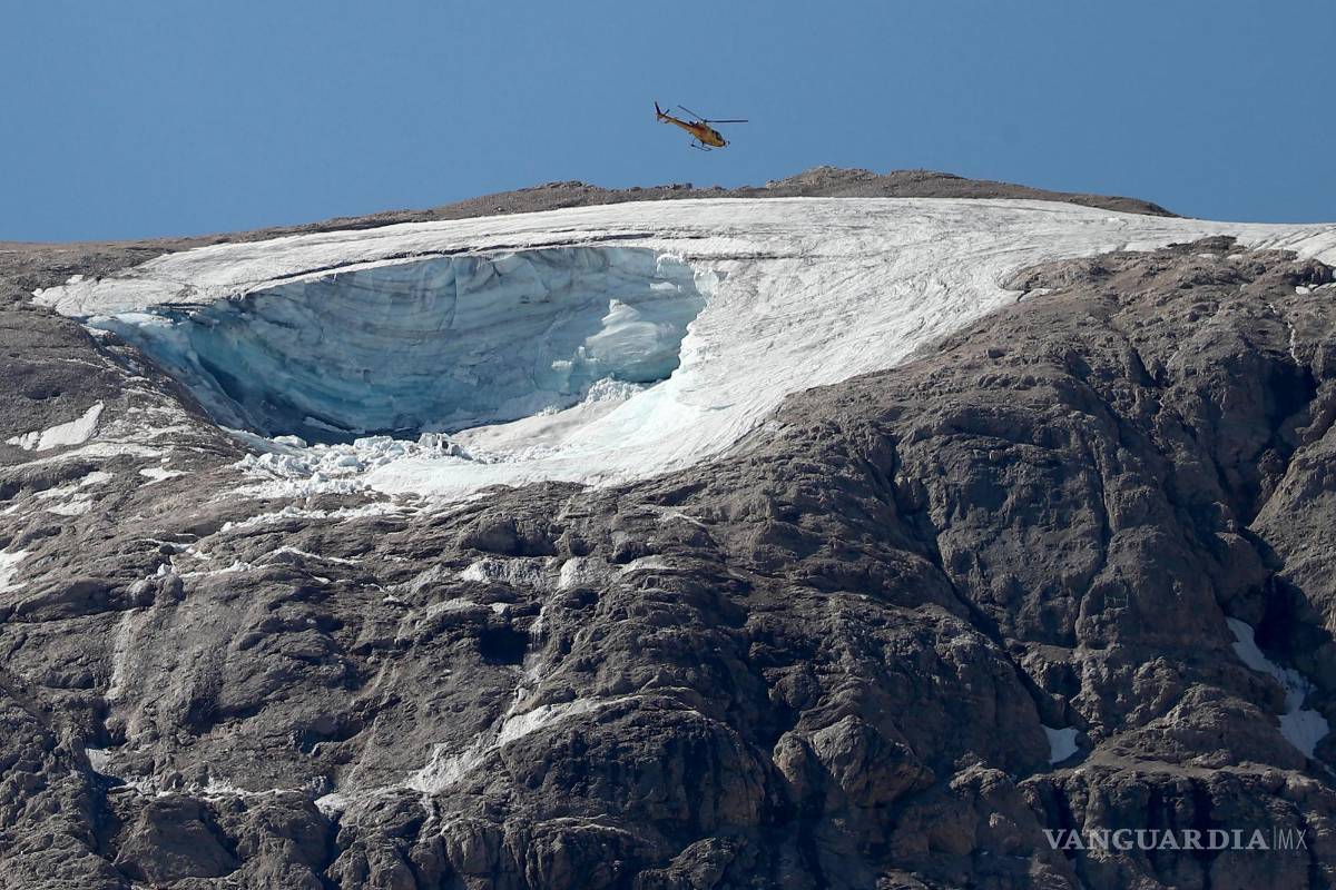 $!Un helicóptero busca a los senderistas desaparecidos tras el desprendimiento de un glaciar de la Marmolada, en los Alpes italianos.