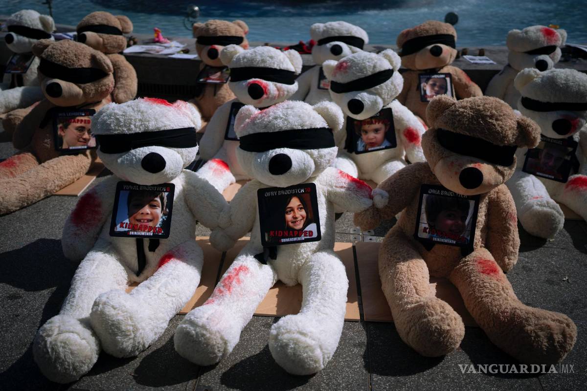 $!En una plaza de Tel Aviv, Israel, se ve una instalación de osos de peluche gigantes con los ojos vendados adornados con fotografías de israelíes cautivos en Gaza.