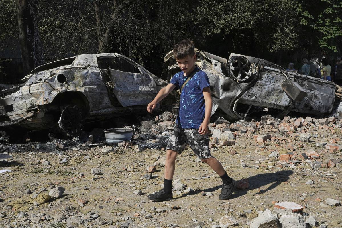 $!Autos dañados yacen en un patio entre otros escombros después de un ataque con aviones no tripulados y misiles rusos en Kiev, Ucrania.