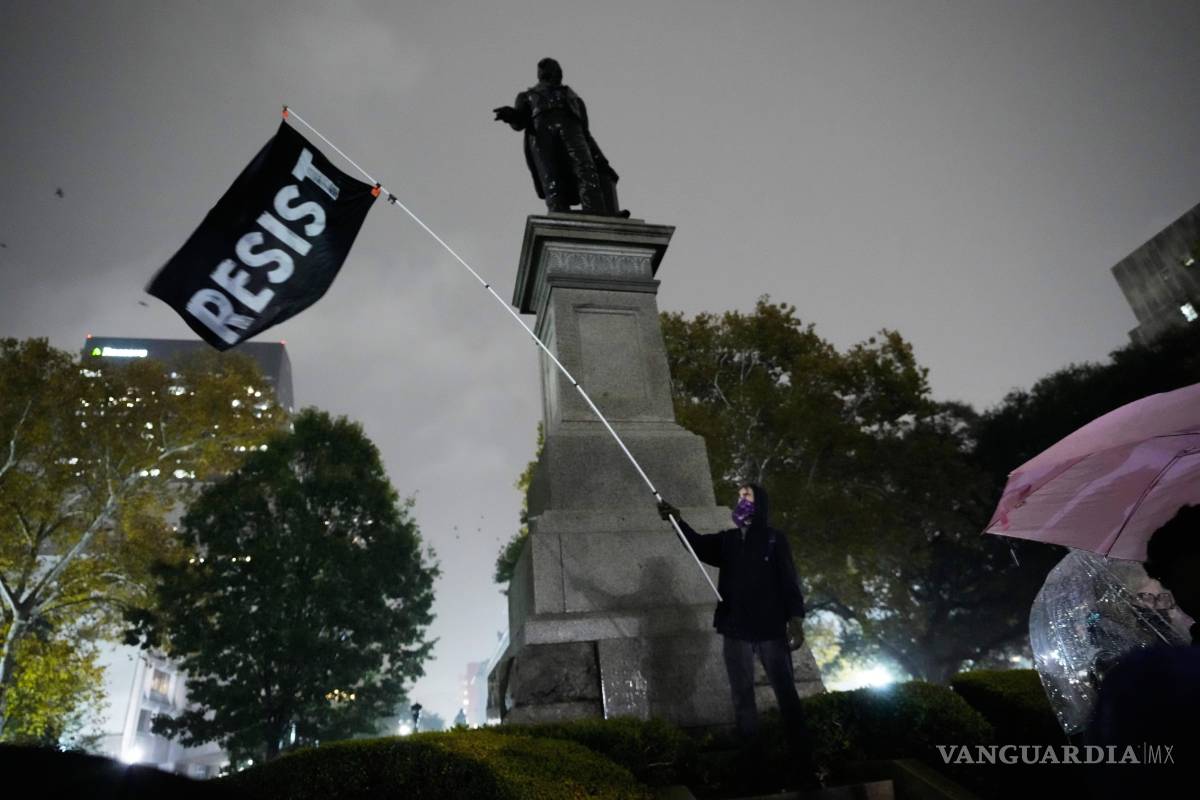 $!Un manifestante bajo una lluvia torrencial durante una protesta contra la inminente ofensiva de la CBP contra la inmigración ilegal en Nueva Orleans.