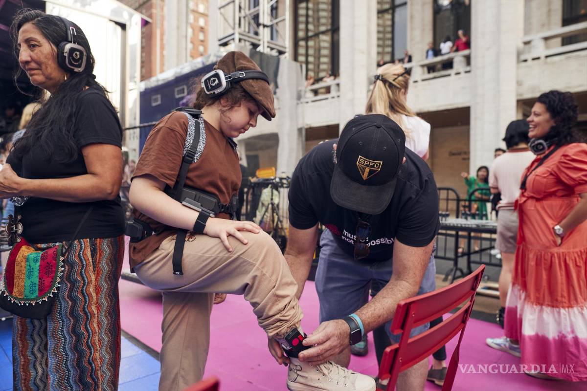 $!Una persona se pone auriculares y las partes conectadas de forma inalámbrica de trajes hápticos para una fiesta disco silenciosa en el Lincoln Center, Nueva York.